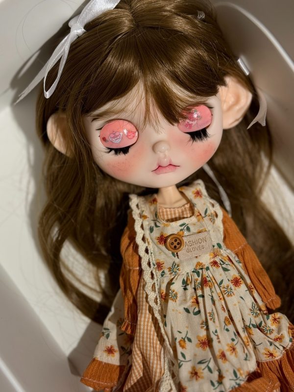 Blythe doll has long curly brown hair