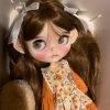 Blythe doll has long curly brown hair