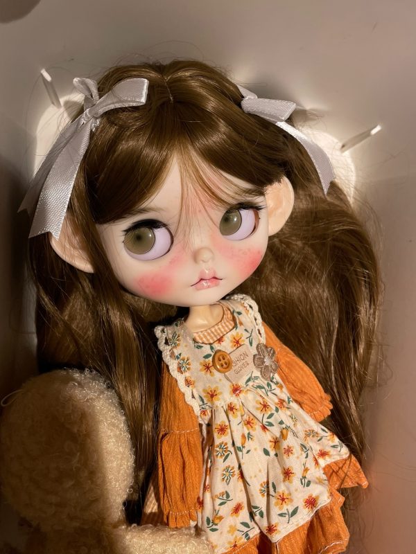 Blythe doll has long curly brown hair
