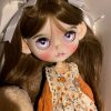 Blythe doll has long curly brown hair