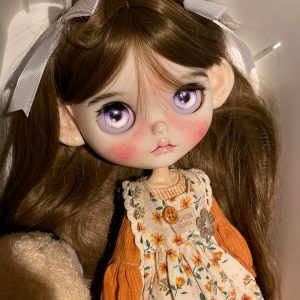 Blythe doll has long curly brown hair