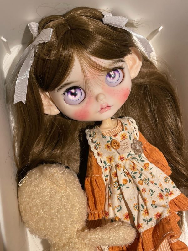 Blythe doll has long curly brown hair