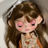 Blythe doll has long curly brown hair