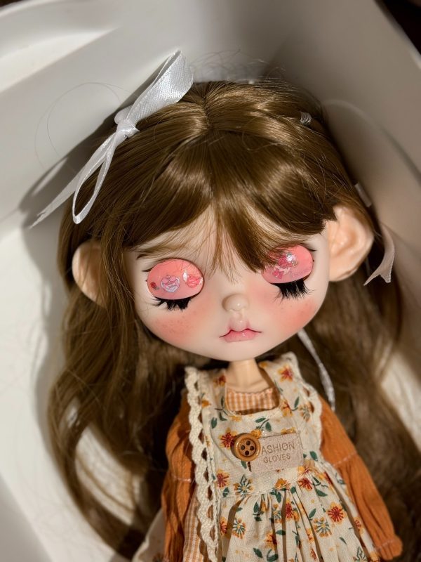 Blythe doll has long curly brown hair