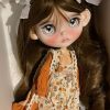 Blythe doll has long curly brown hair