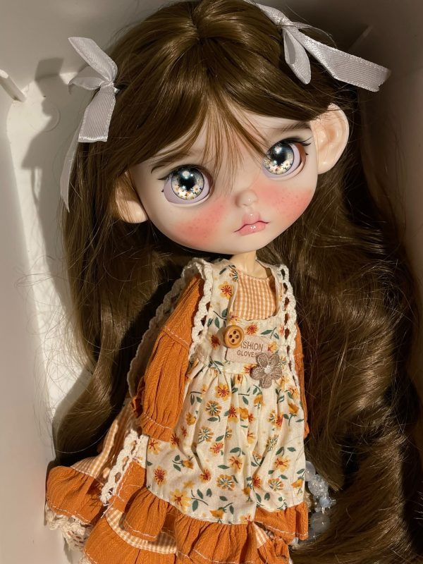 Blythe doll has long curly brown hair