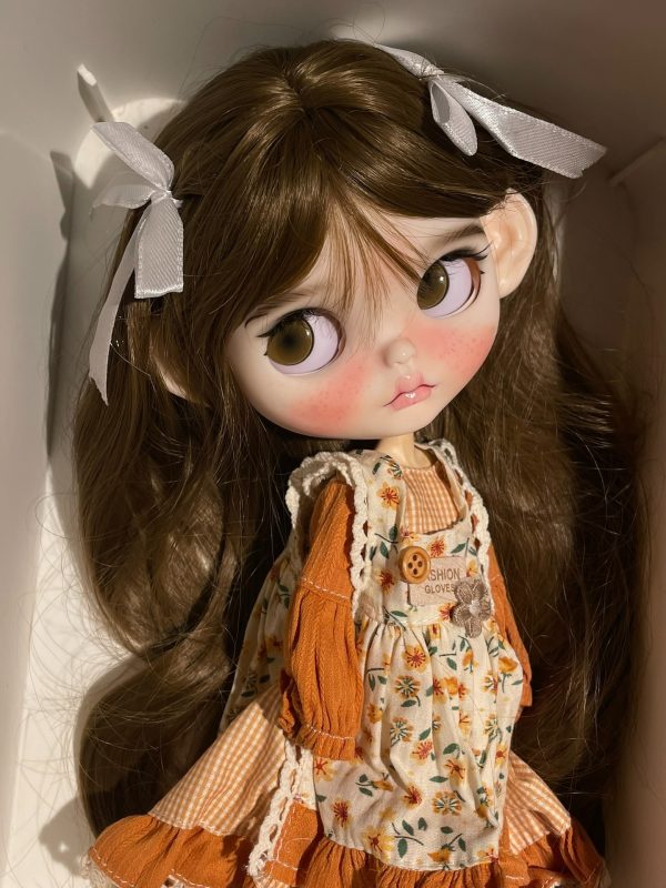 Blythe doll has long curly brown hair